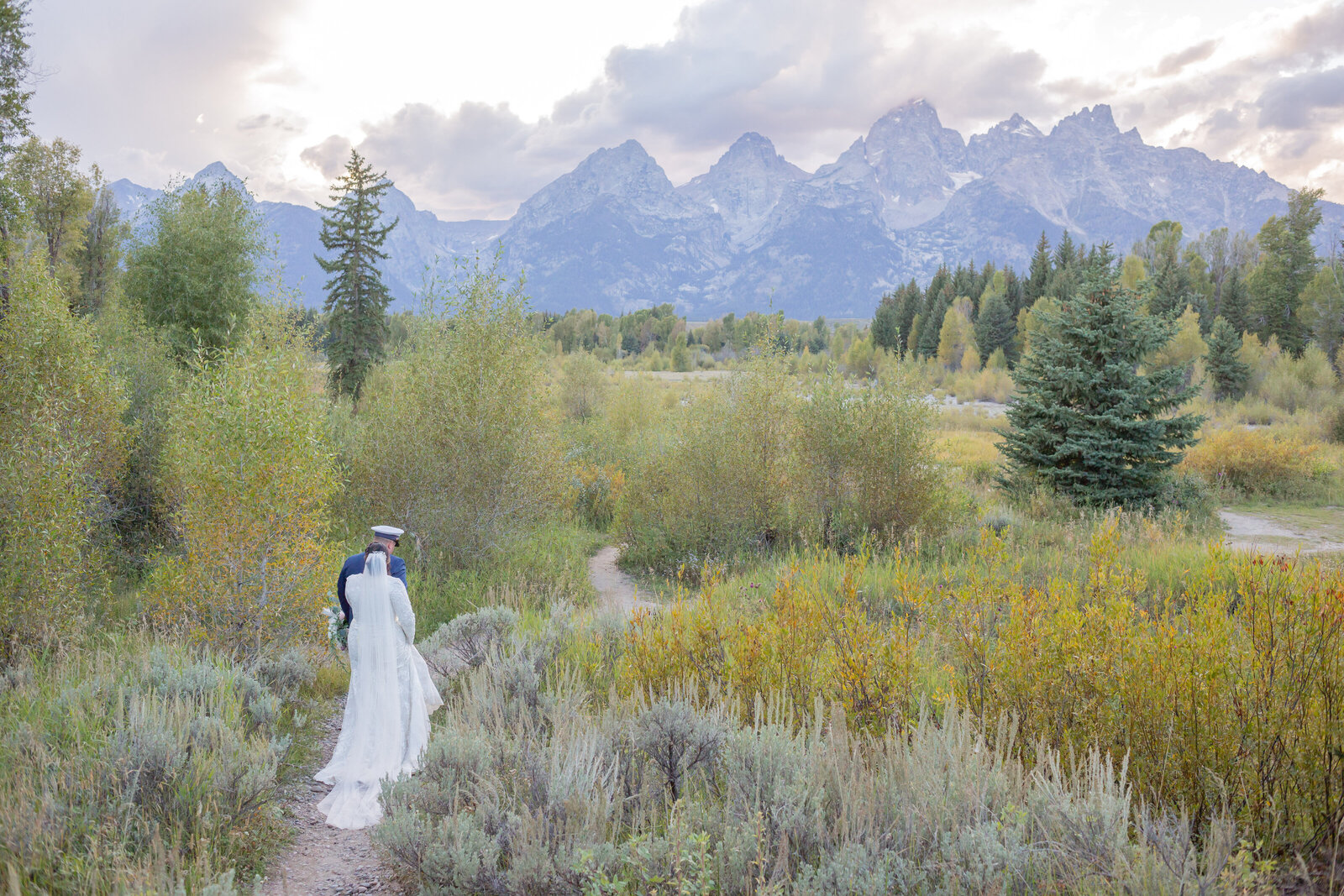 Seattle Wedding Photographers capture bride and groom walking through Tetons