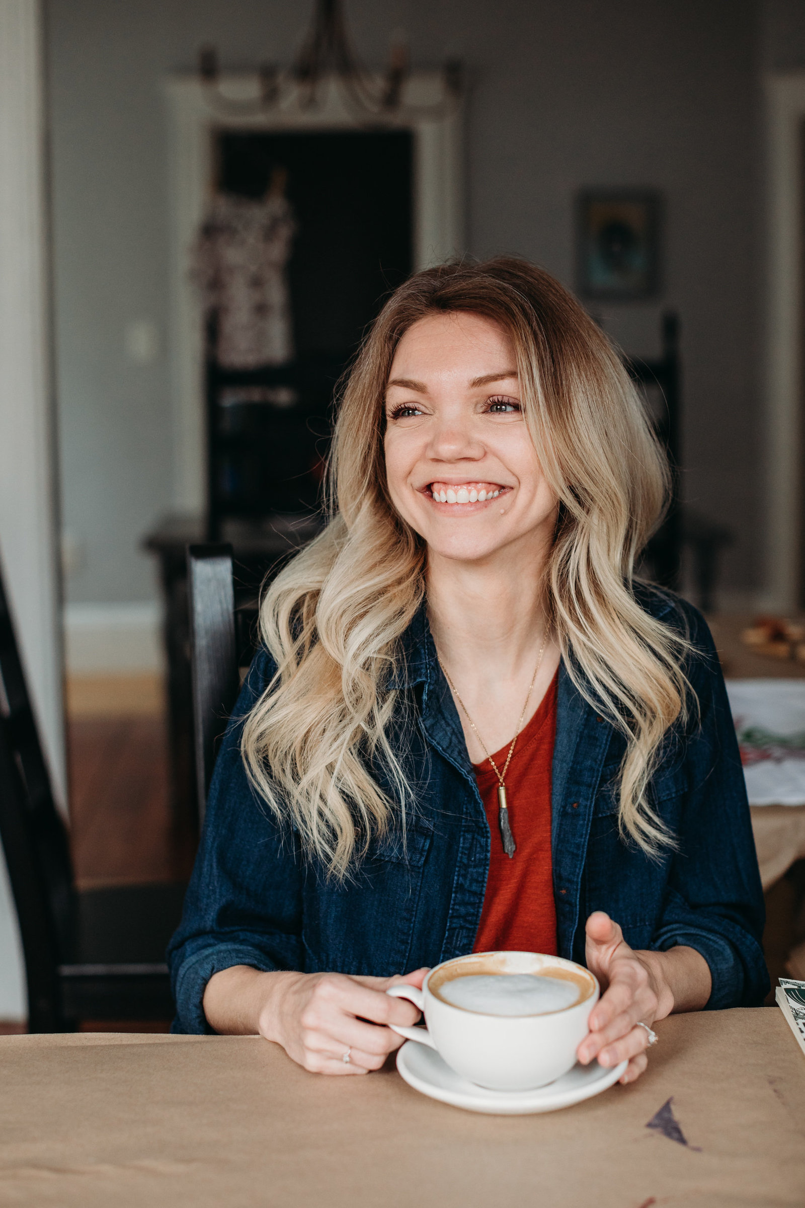 woman with latte smiles in home studio