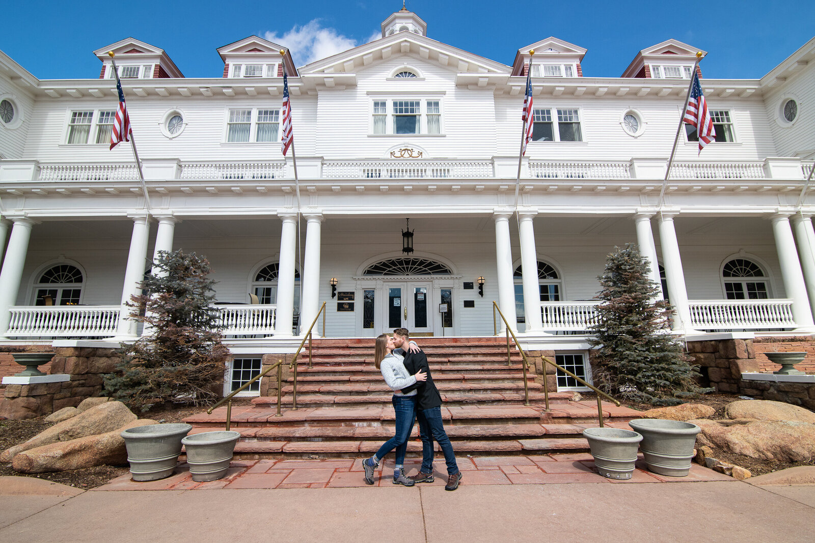 Man and woman kiss in front of the Stanley Hotel in Estes Park, Colorado.