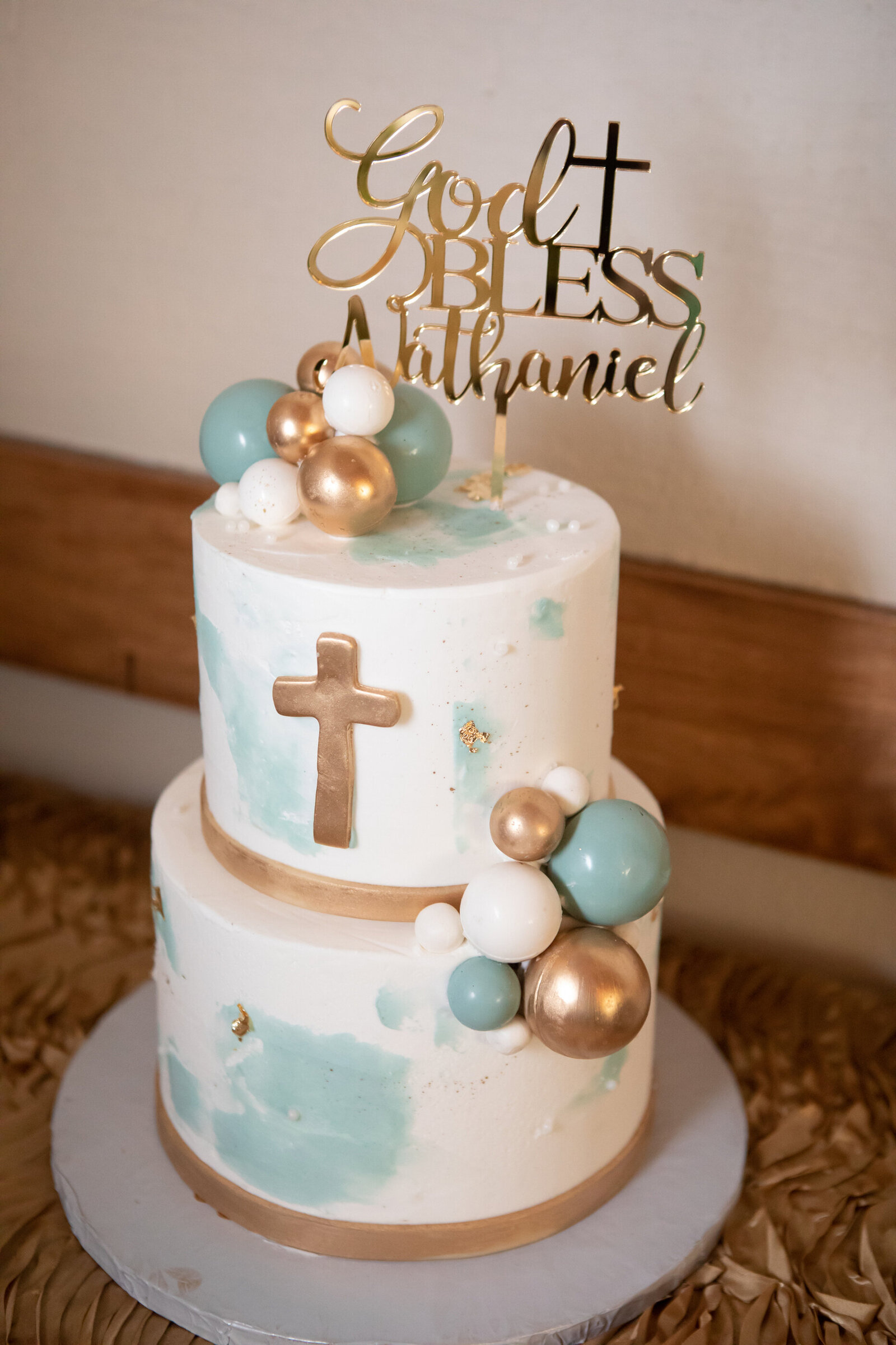 three tier cake with blue gold and white icing and cross on it with cake topper God bless nathaniel New City Rockland County baptism photographer Milestone Images