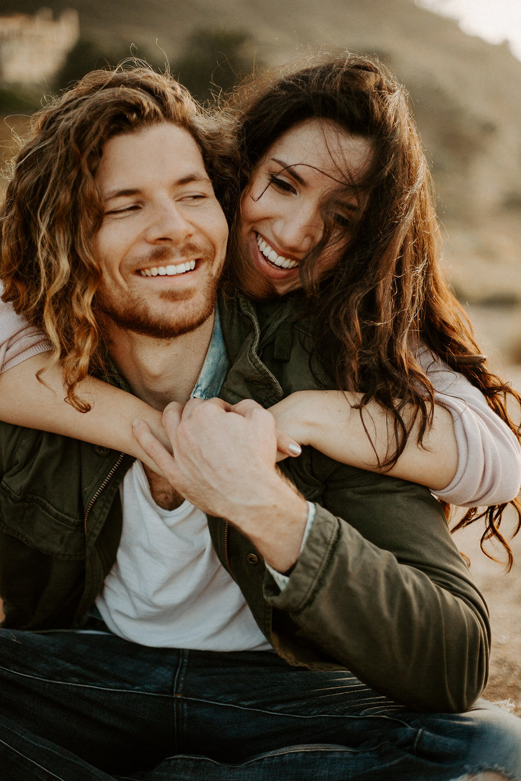 Woman hugging her man from behind during their California engagement session