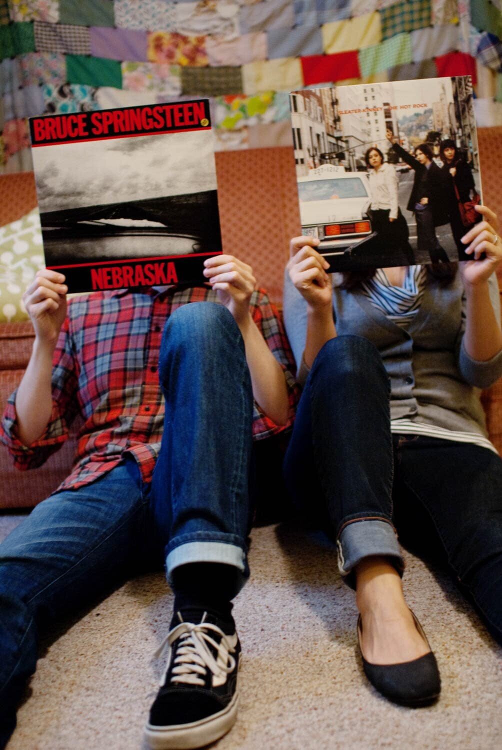 a couple cover their faces with a bruce springsteen and sleater kinney record cover