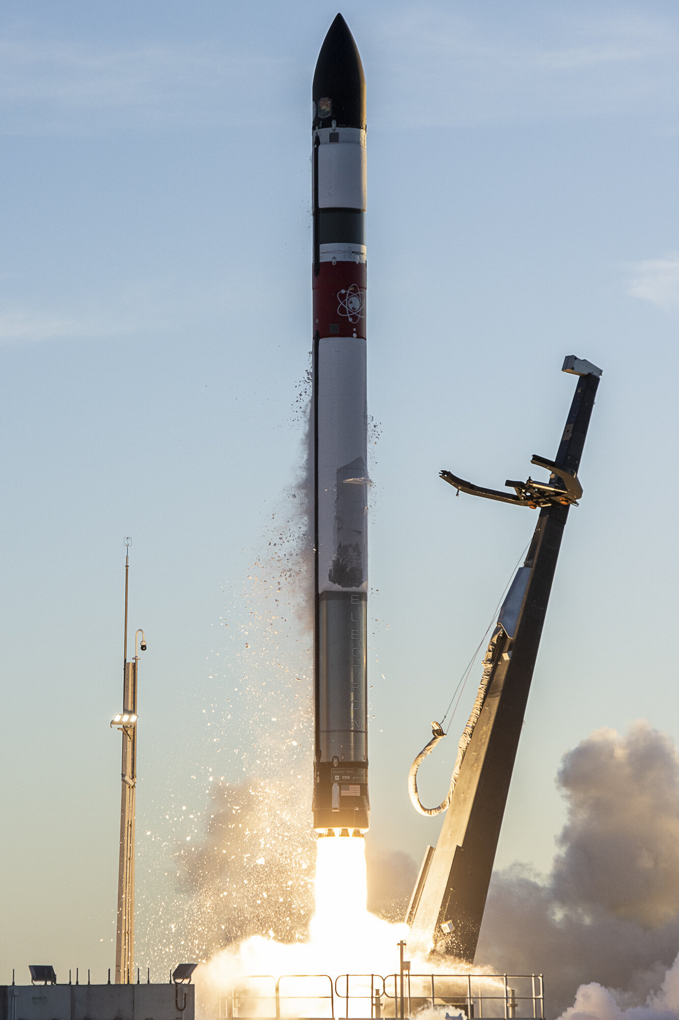 Rocket Lab's Electron rocket launching. Leaving the launch pad. Pad alight from engine fire.