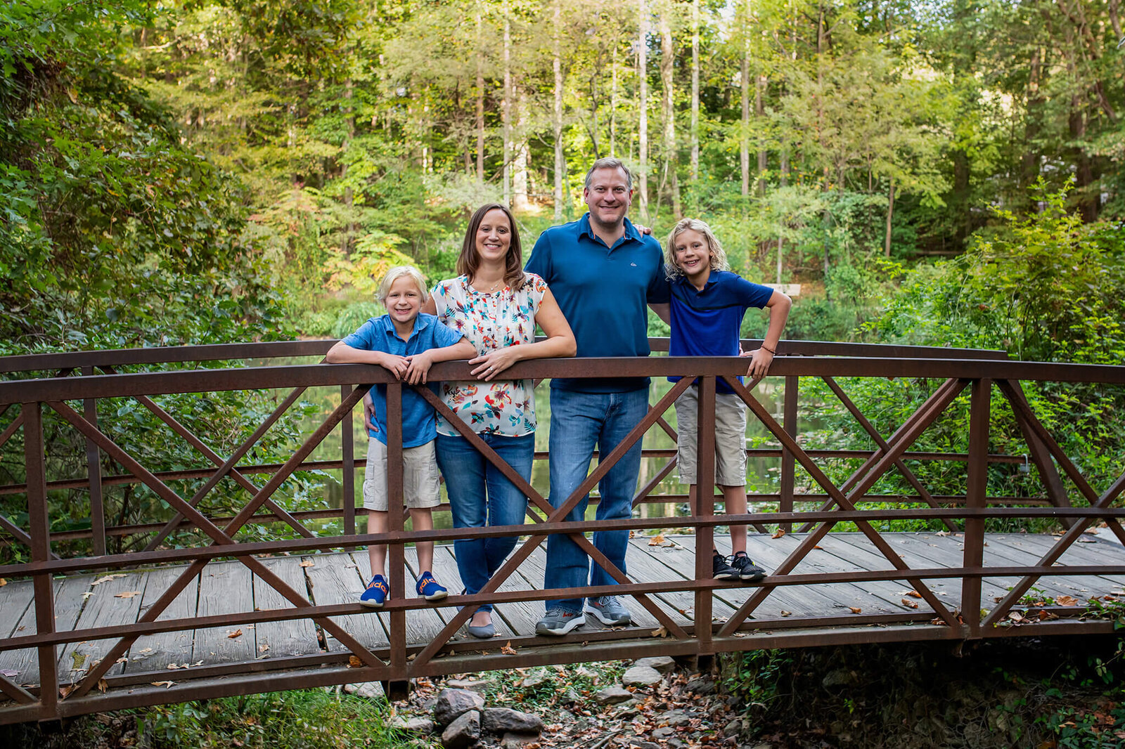 A family of four posing on a bridge at a park in Northern Virginia.