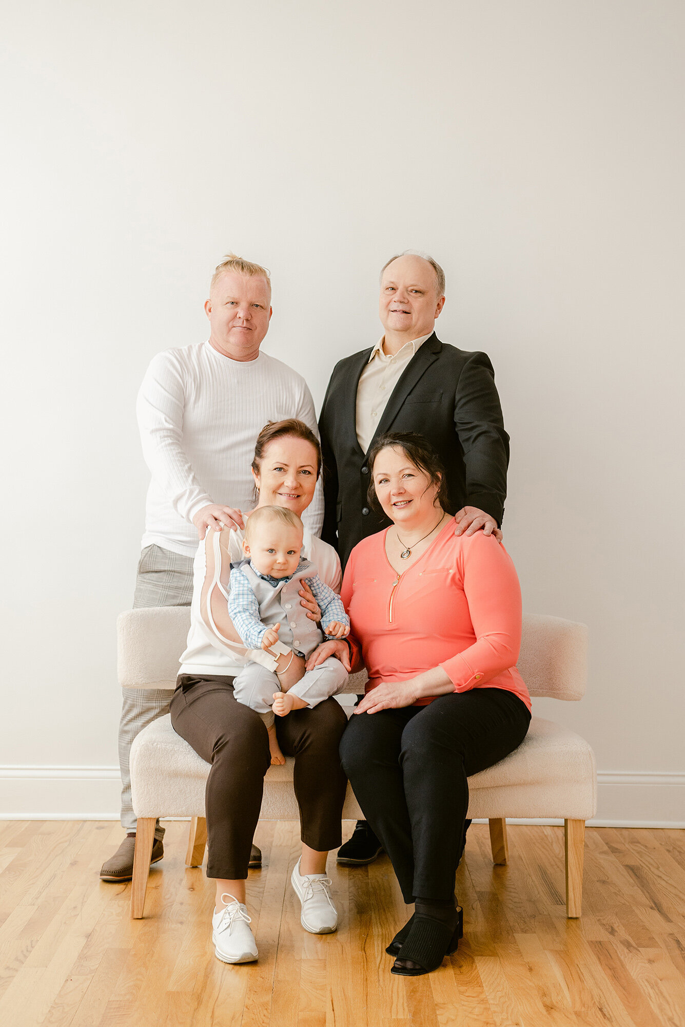 Portrait of a one year old baby with both sets of grandparents in a studio