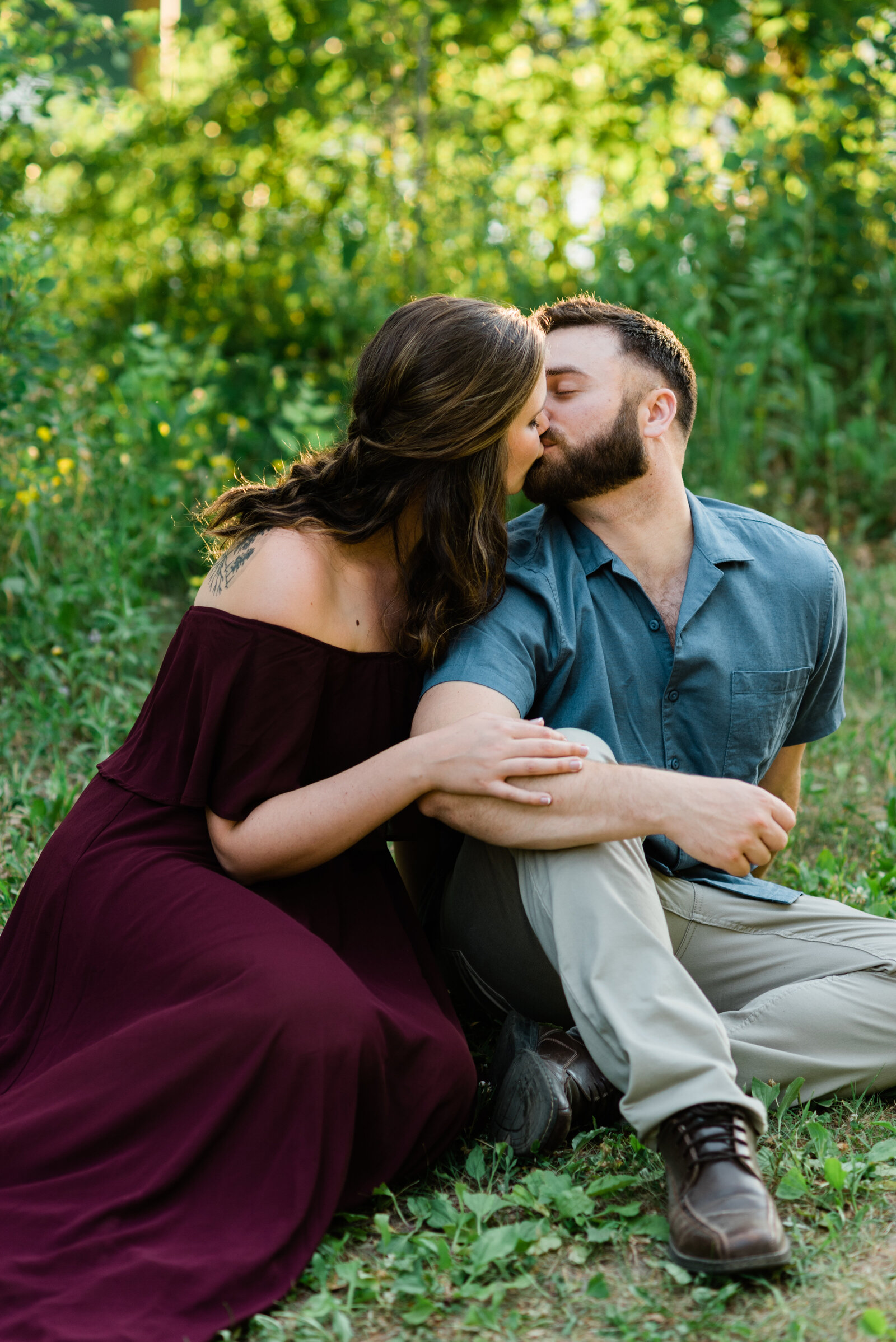 Couple sitting in the grass kissing