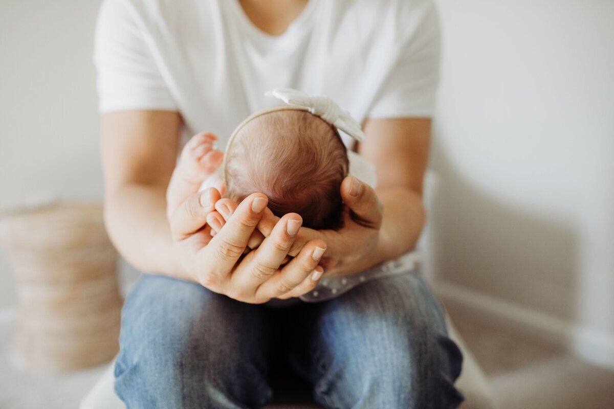 Parent holding and looking at newborn baby by nj newborn photographer