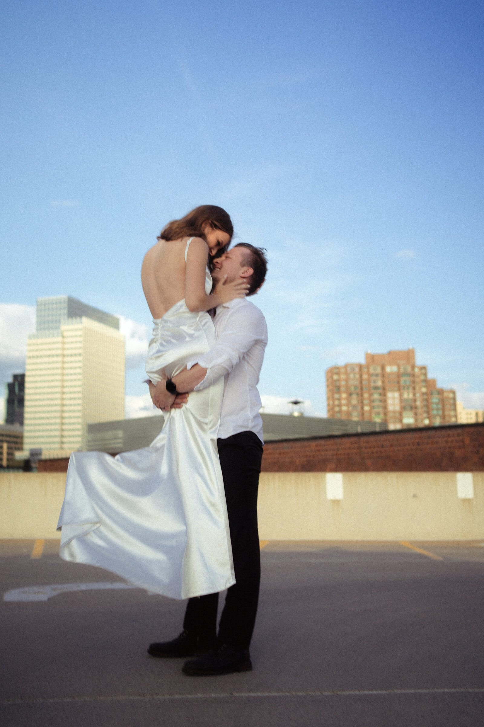 groom holds bride up to the skyline  Best Virginia couples photographer