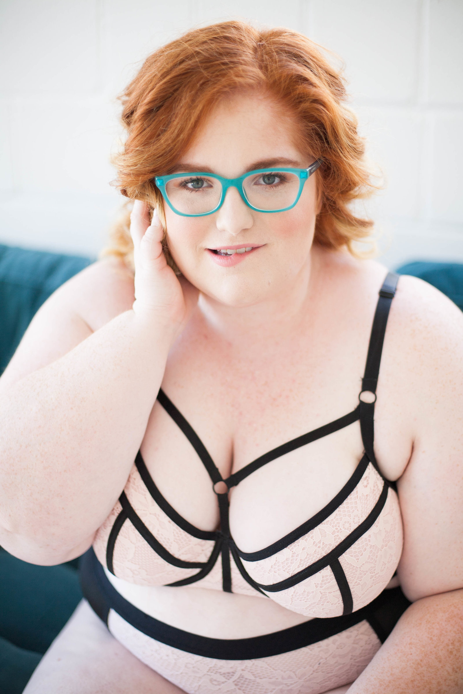 A redhead wearing white and black lingerie.