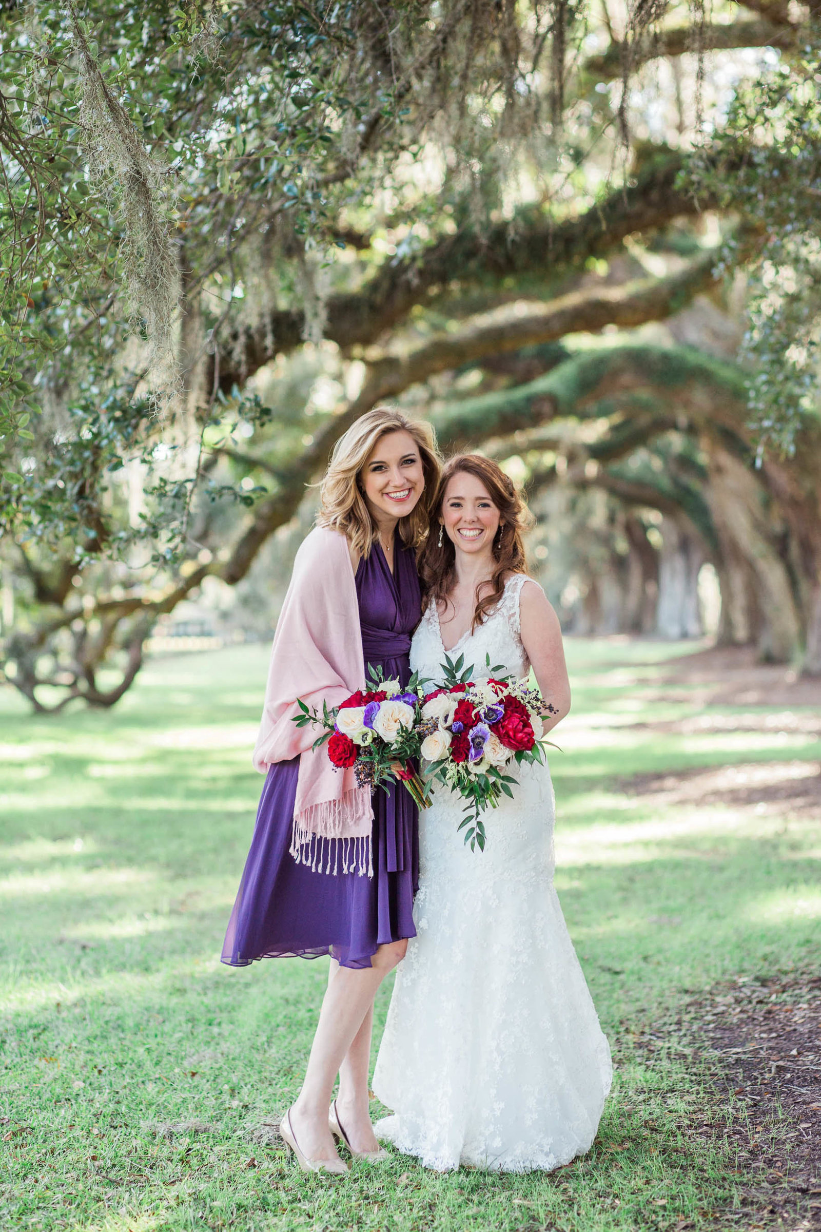 Bride and bridesmaids stand on avenue of oaks, Boone Hall Plantation, Charleston, South Carolina