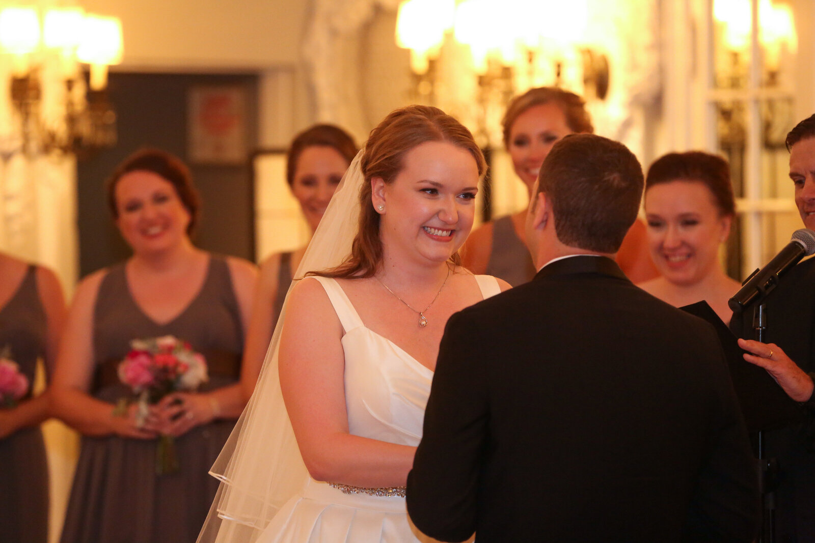 Bride smiles at her groom as she takes her vows