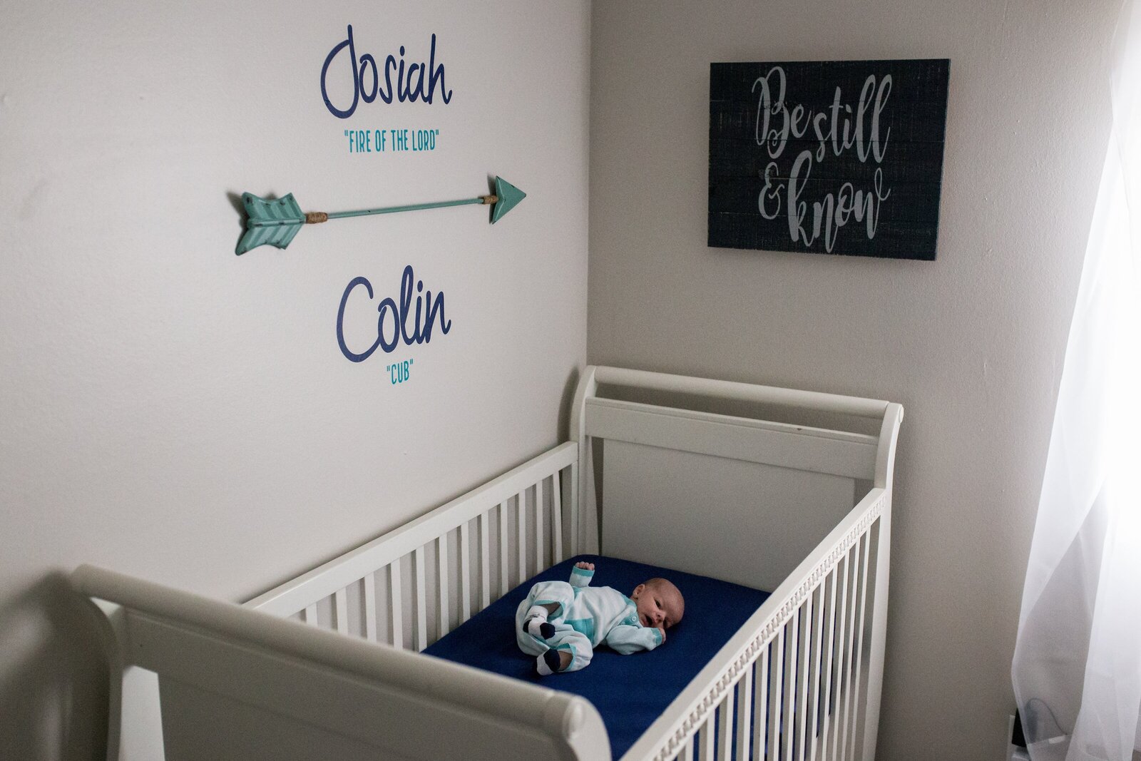 newborn boy lying in crib during in-home newborn session in Pensacola.