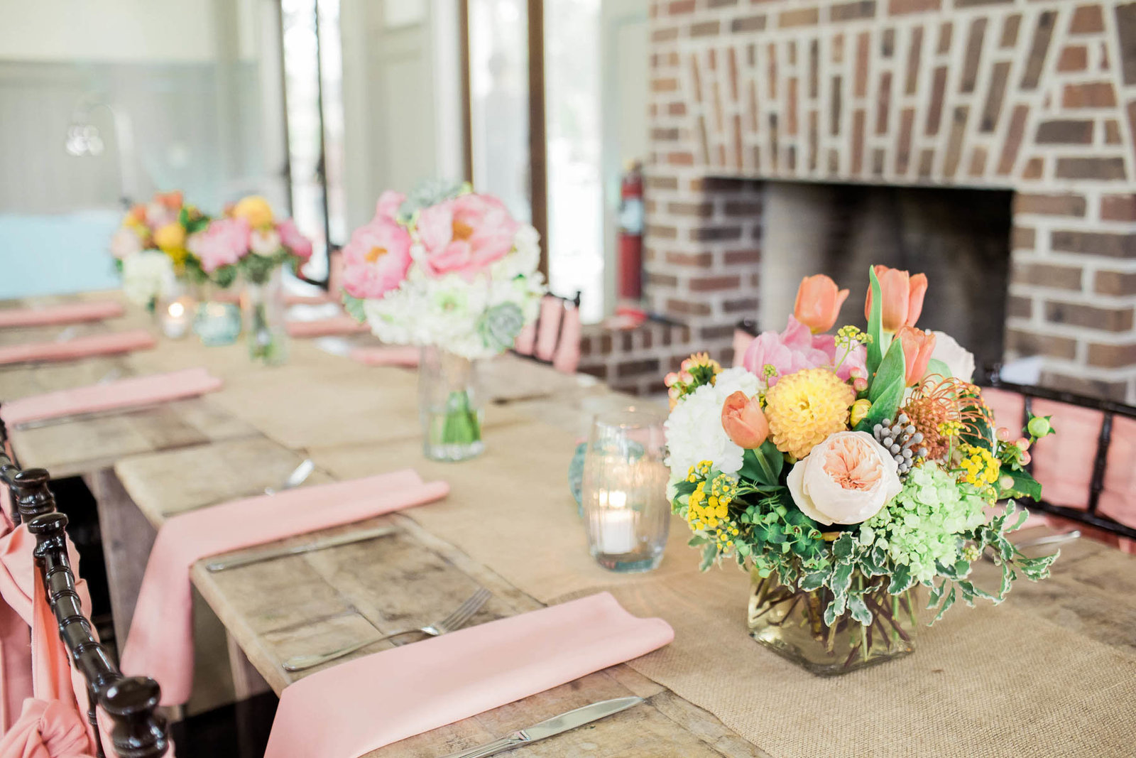 Orange, yellow, and pink floral arrangement is placed on each table, I'on Creek Club, Charleston Wedding Photographer.