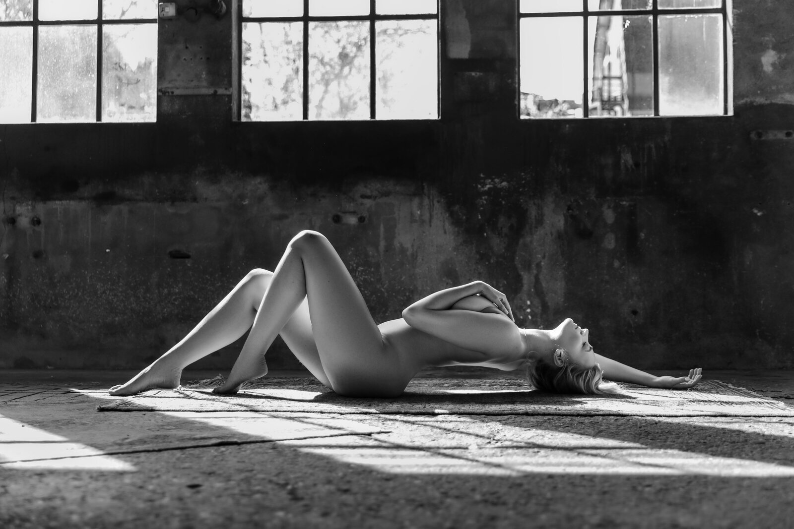 zwart-wit-bewerkte-foto-sensuele pose-op-industriele-vloer