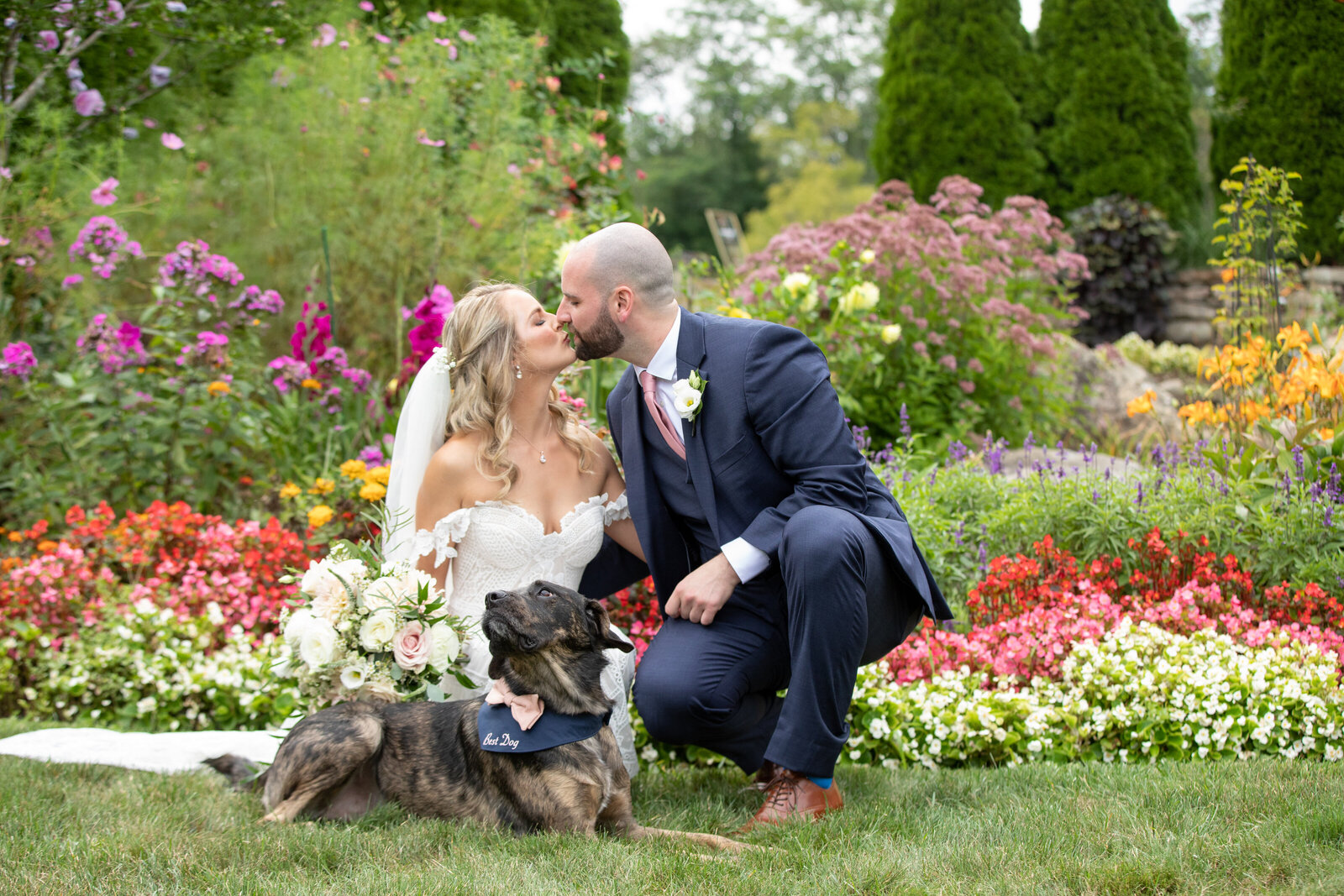 couple poses in summer garden with dog