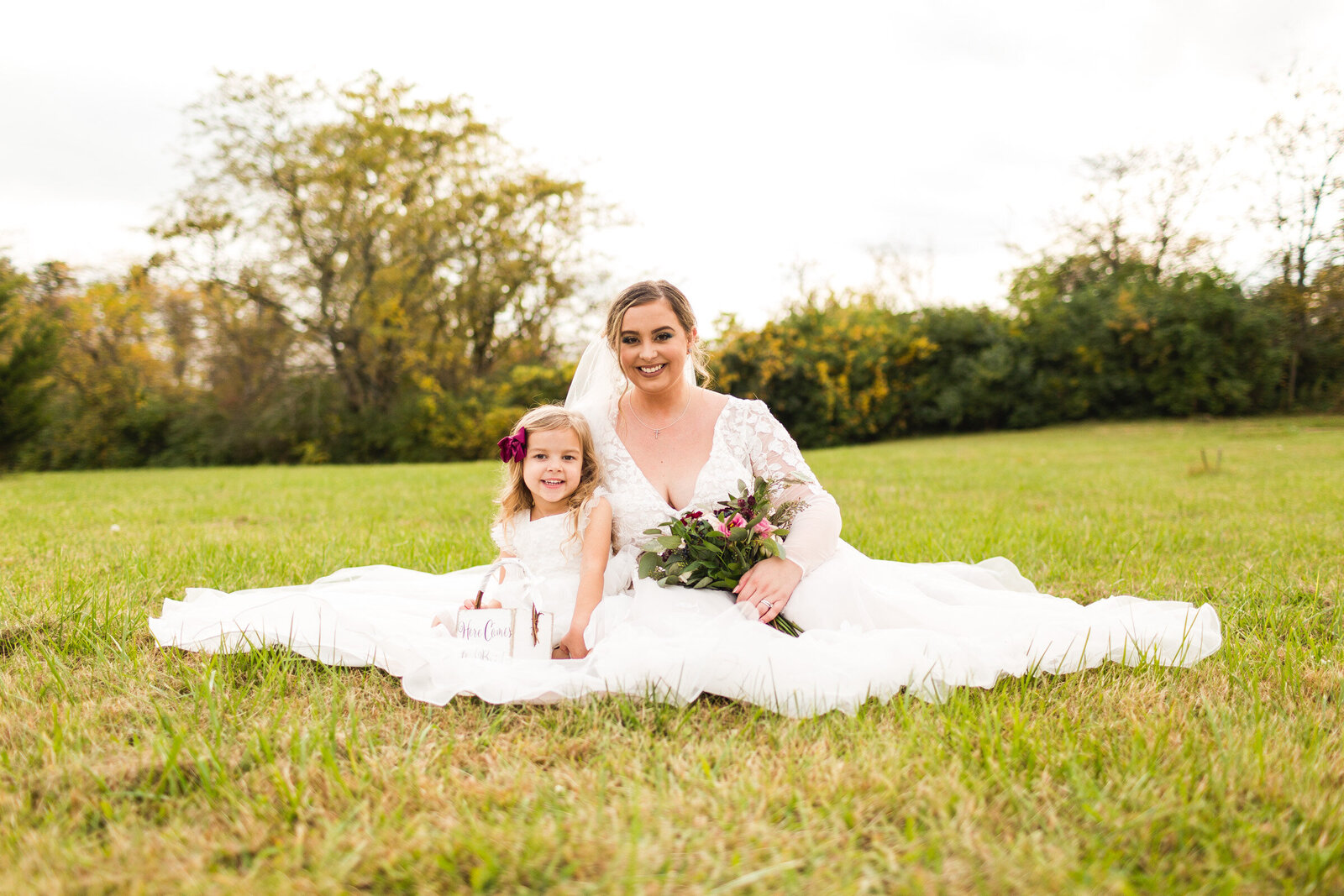bride and flower girl sitting for portrait together ohio