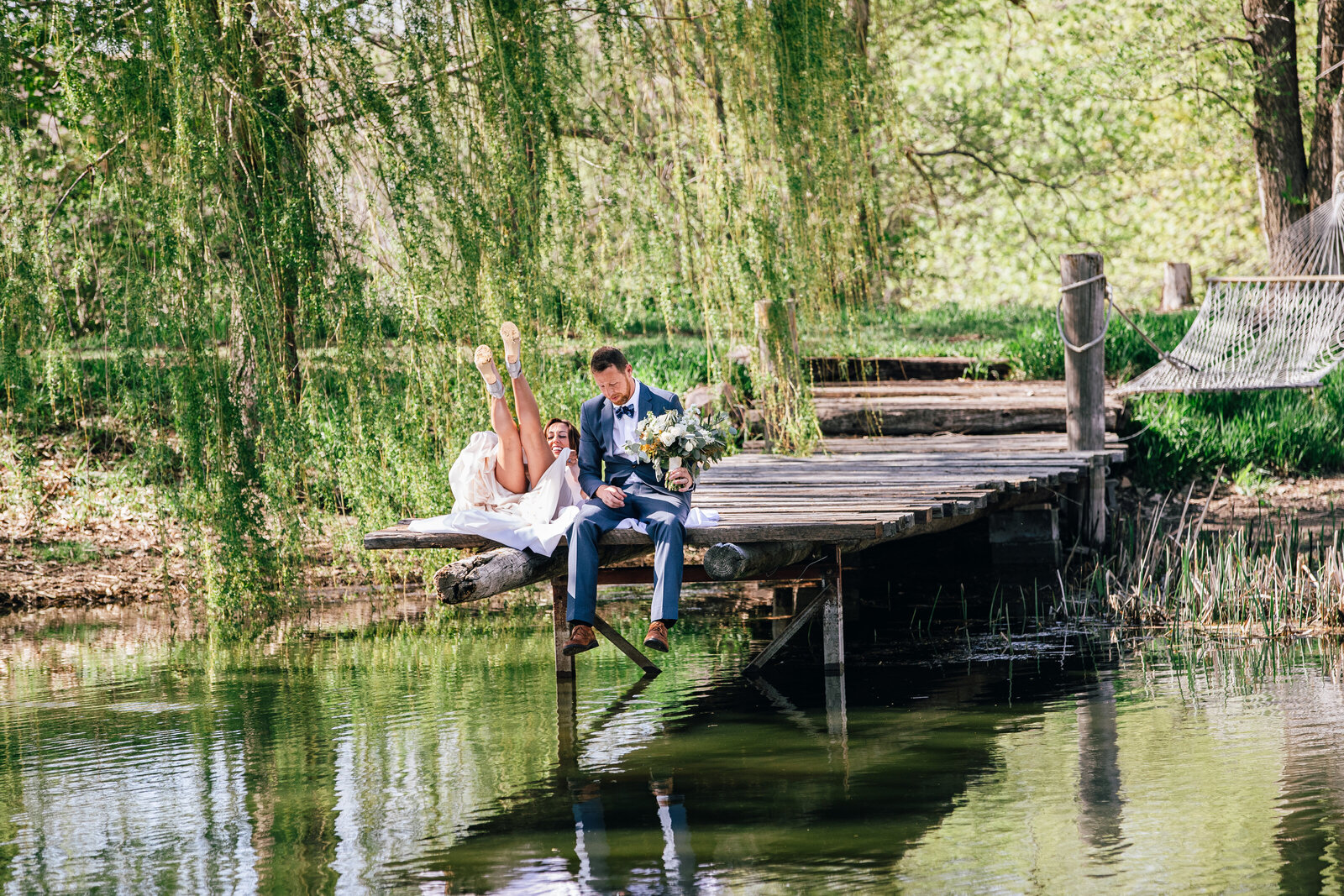 Bride and groom sitting on a dock