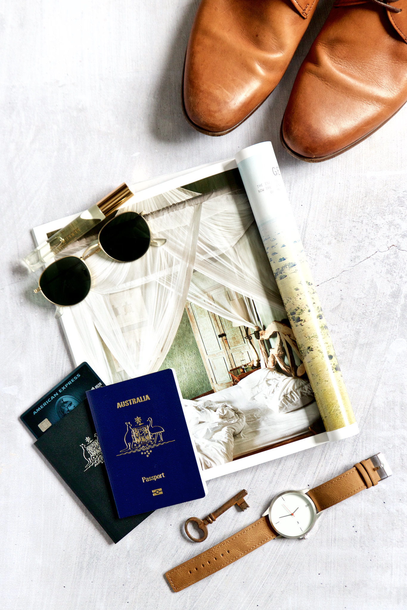 Styled flat lay by branding product photographer Chelsea Loren with passports, magazine, men's shoes, watch for masculine travel flat lay.