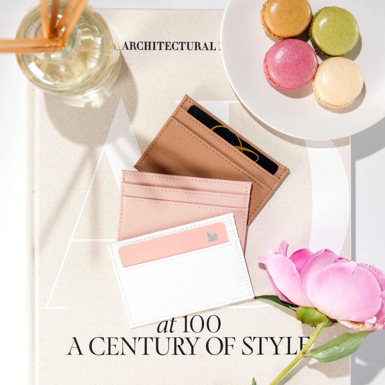Etsy product photographer styled flat lay featuring leather card holder wallets feminine with peony and macarons