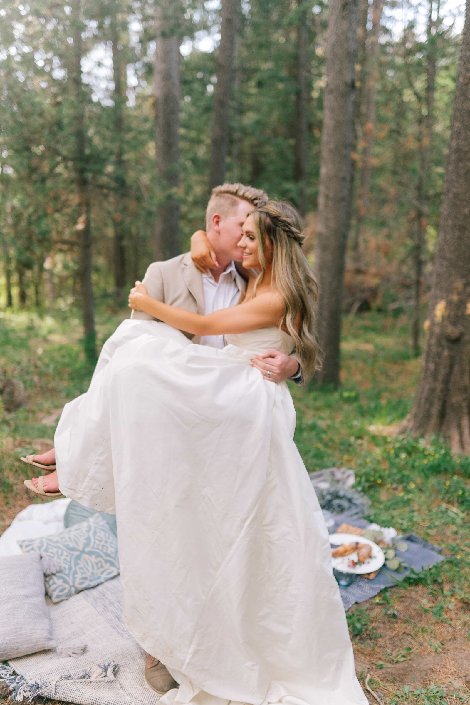 Sacramento wedding photographers capture groom lifting bride after intimate wedding picnic