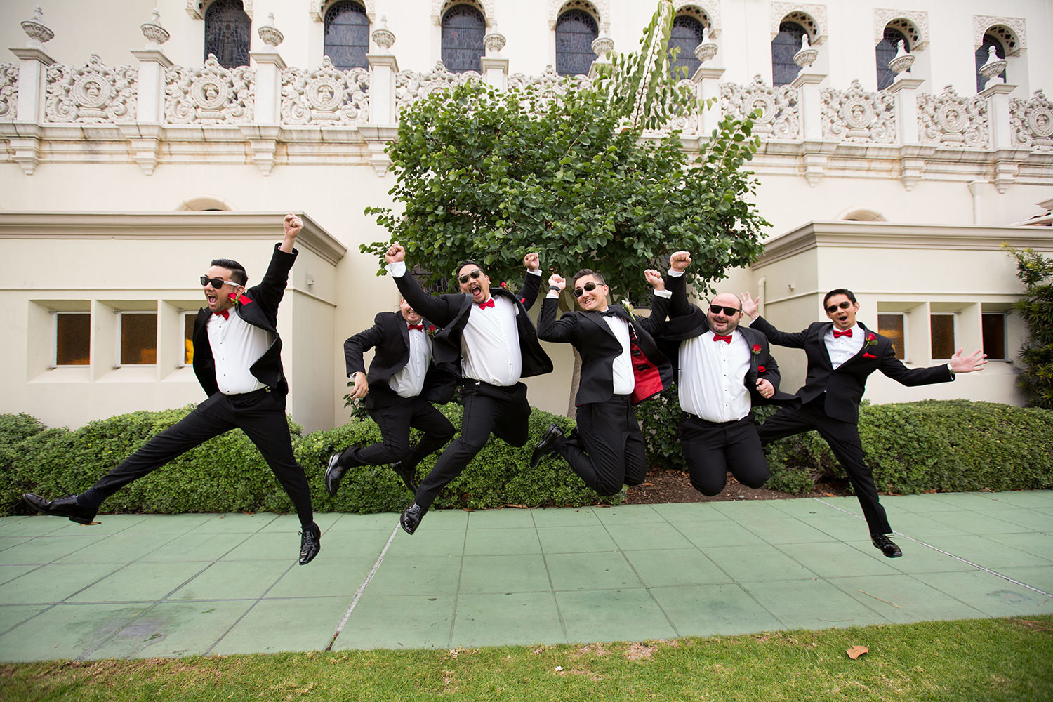 groomsmen jumping in front of the immaculata