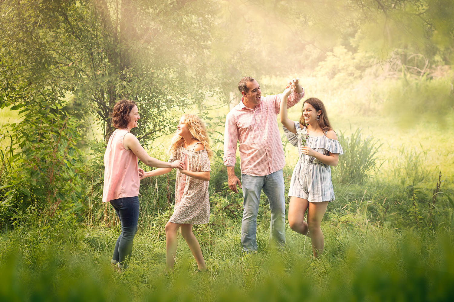family dancing in a field