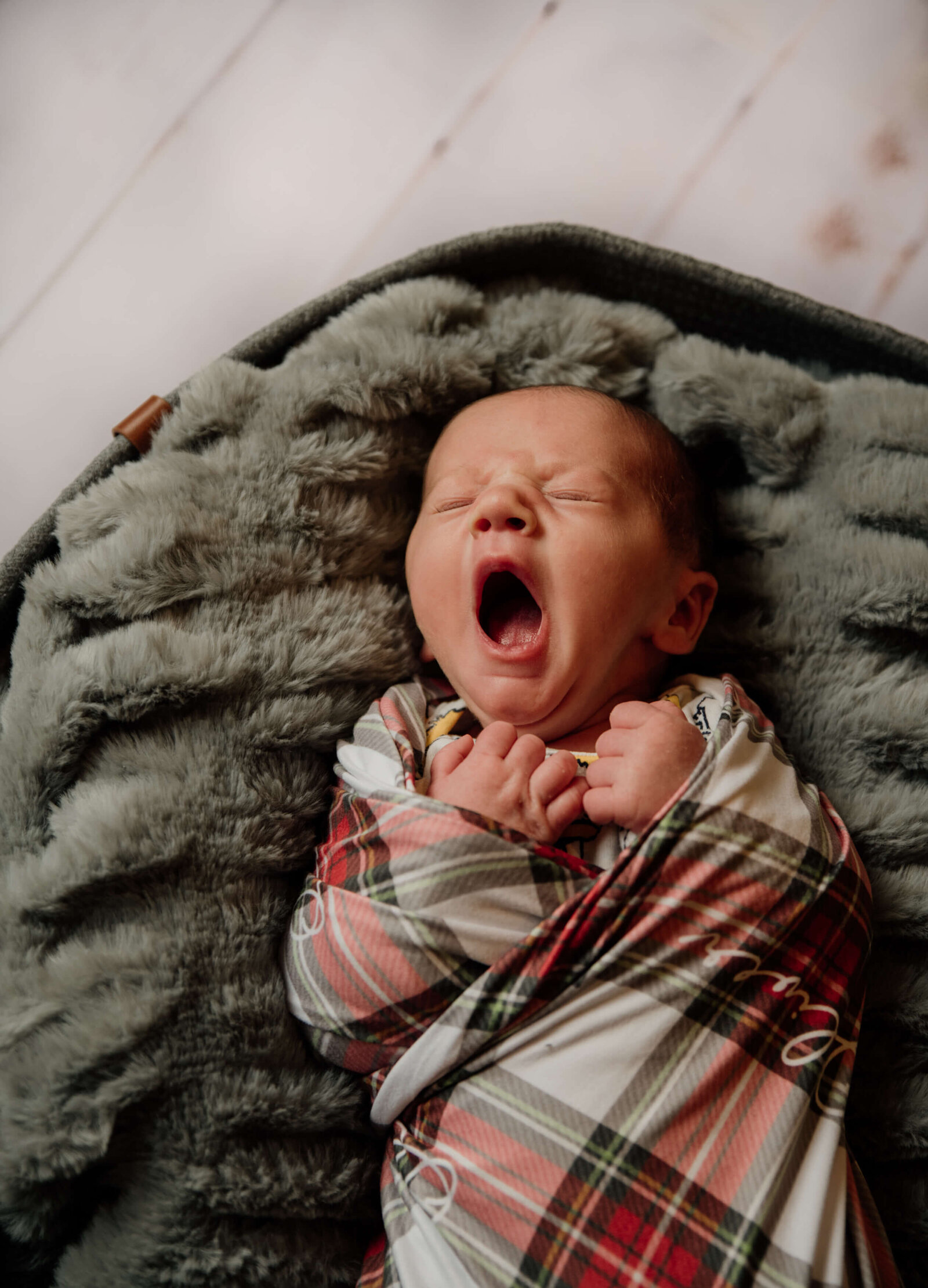 Yawning baby in basket.