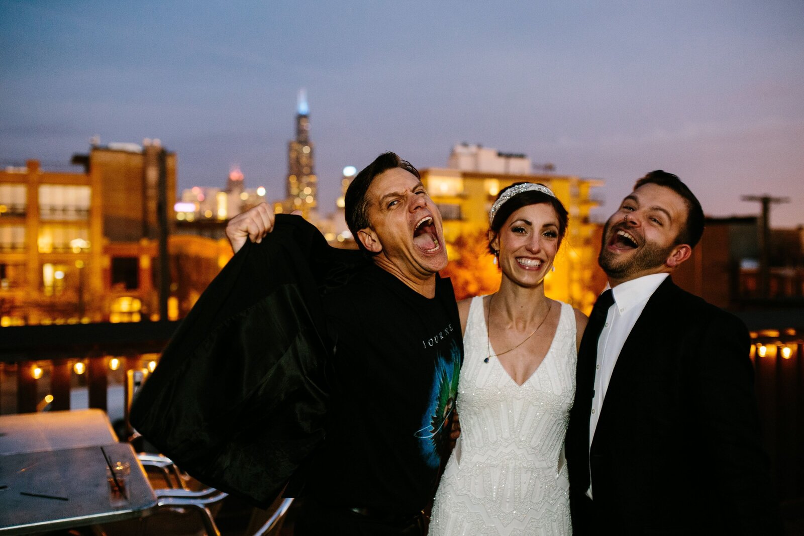 Bride and groom smile with wedding officiant after their wedding ceremony with Chicago skyline in the background