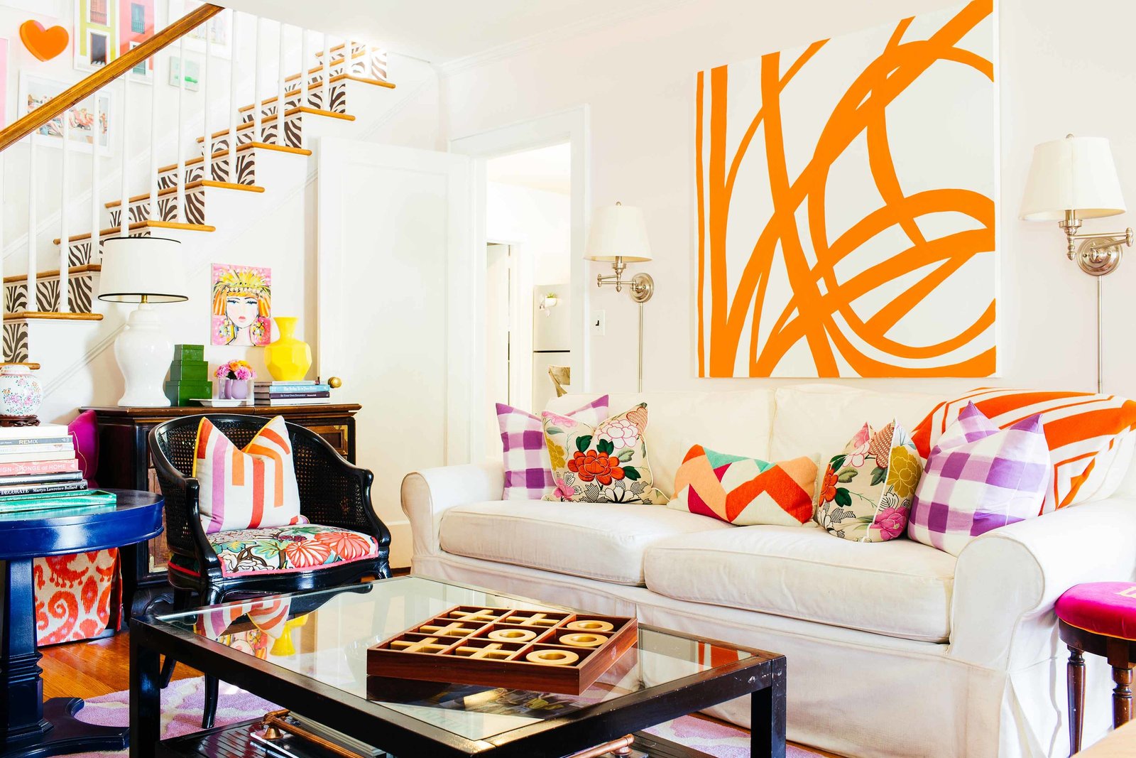 A living room with a large orange and white abstract painting.