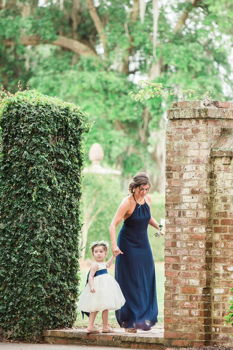 Flower girl steps into the garden, Dunes West Golf and River Club, Mt Pleasant, South Carolina. Kate Timbers Photography.