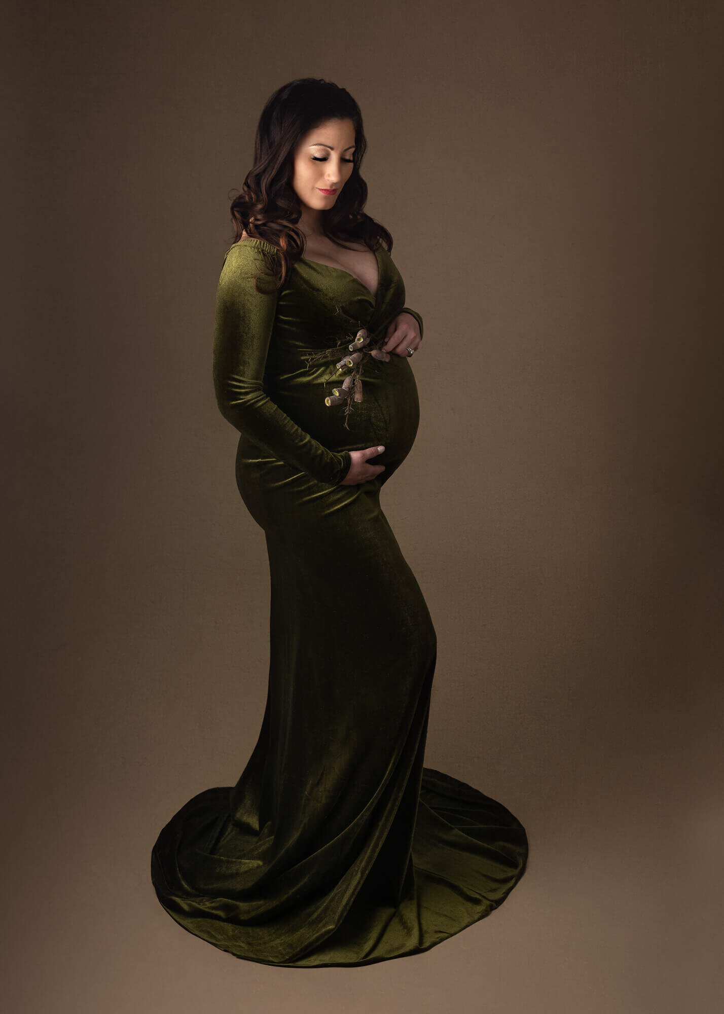Fine-art maternity picture of woman in a green gown