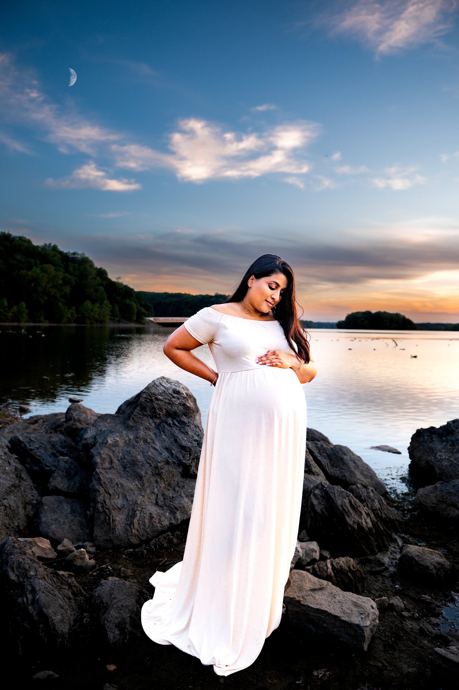 pregnant woman holding her belly with the moon in the sky