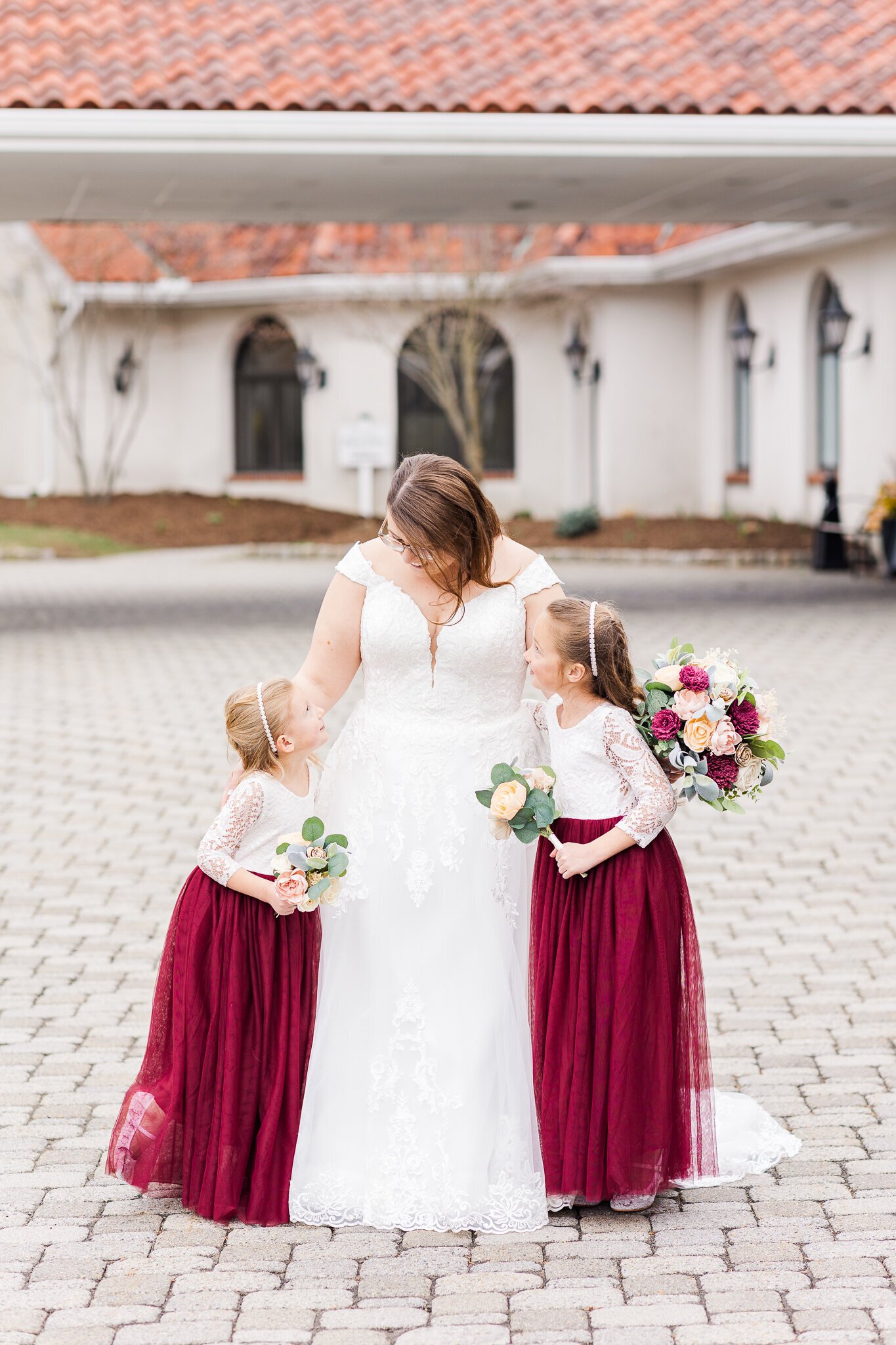 bride hugging two little flower girls