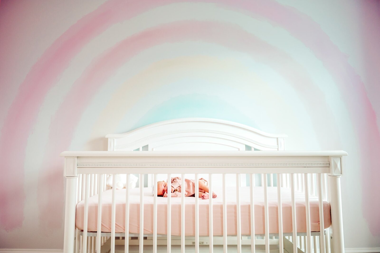 newborn baby girl in crib in nursery