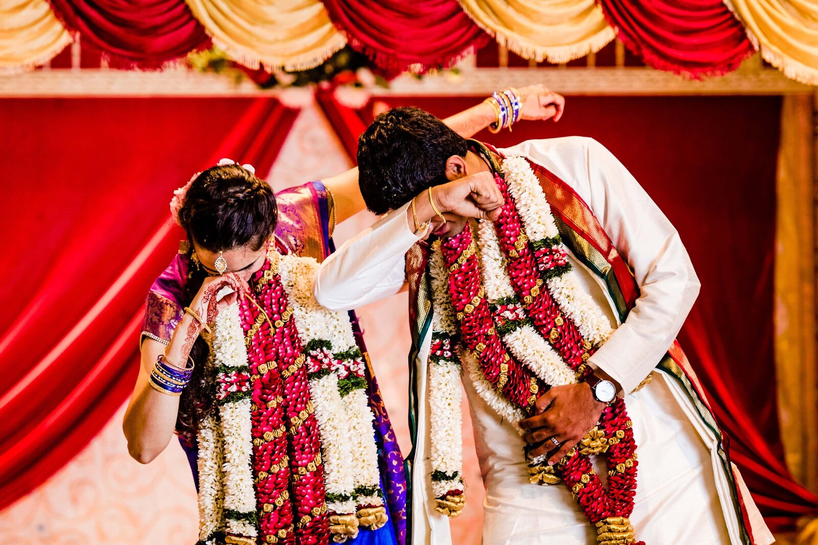 Indian couple in traditional attire dab in front of the mandap after their Indian wedding ceremony in Raleigh, North Carolina