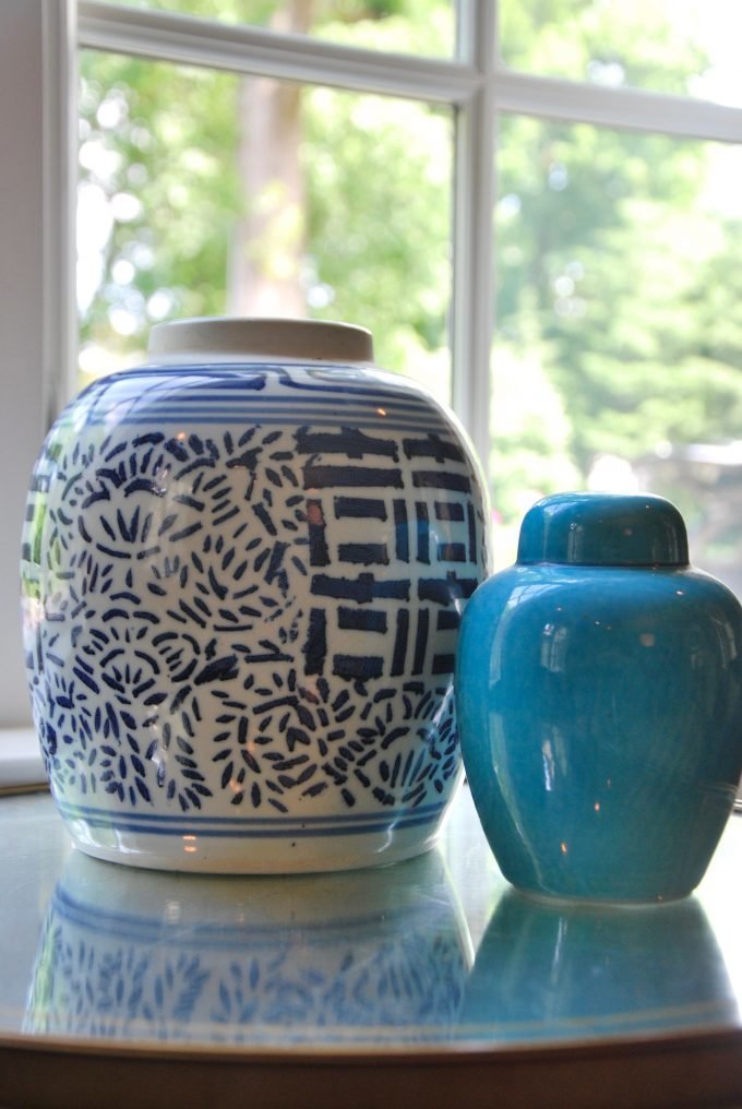 Blue and white, and turquoise ceramic vases on a glass accent table.
