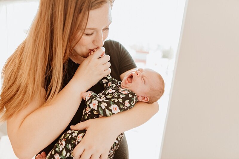Mom kissing baby's hand at Vancouver newborn photography session