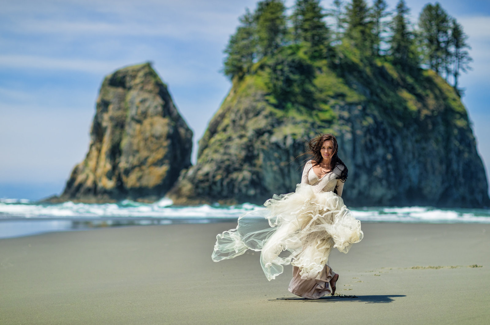 Bride walking on beach enjoying the wind