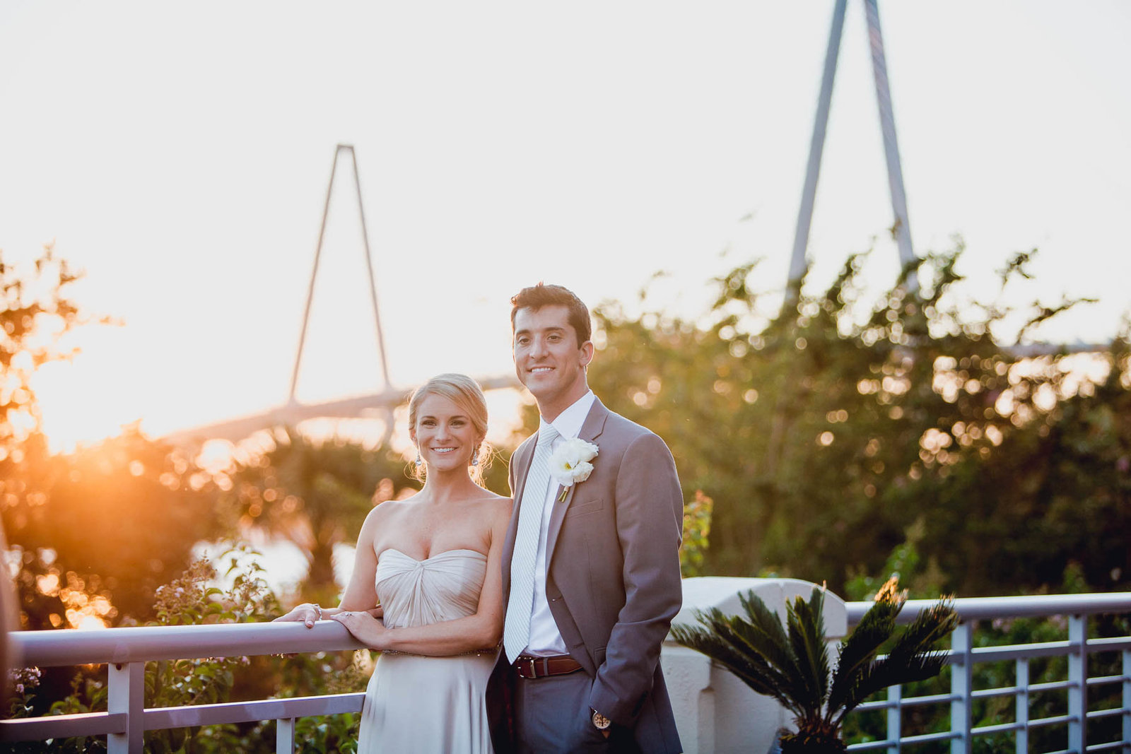 Bride and groom pose at sunset with Ravenel Bridge in background, Harborside East, Mt Pleasant, South Carolina