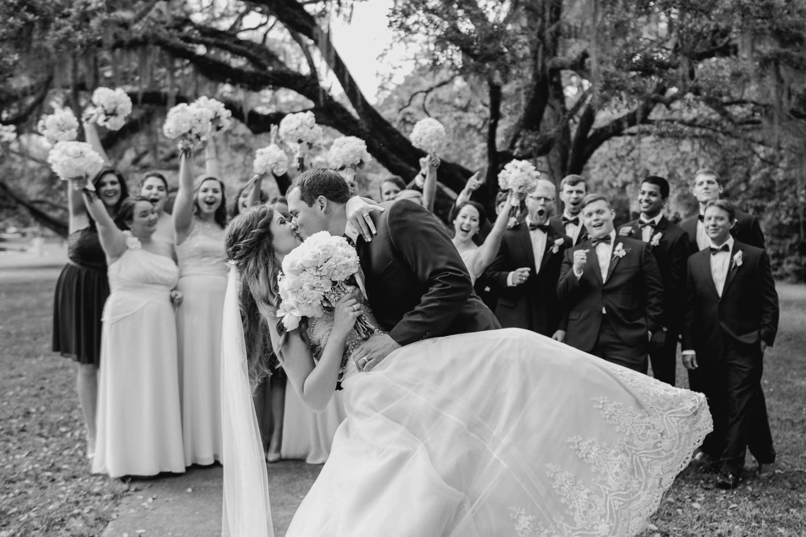 Bride and groom kiss while wedding party cheers, Brookgreen Gardens, Murrells Inlet, South Carolina