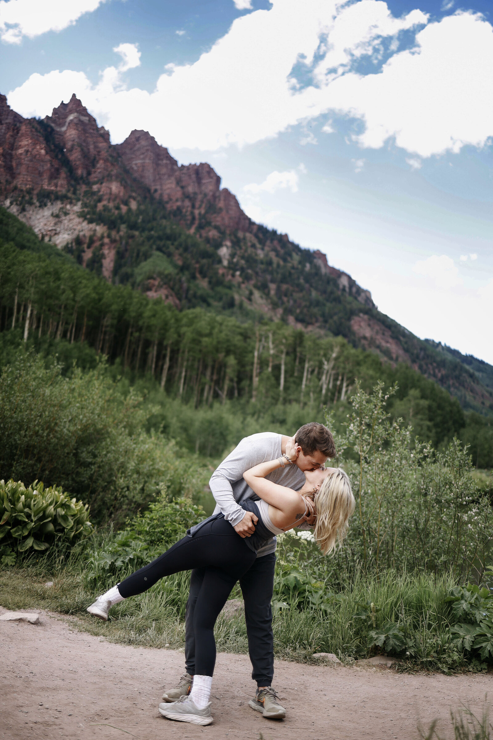 A cute couple kisses with the Maroon Bells mountains in the backdrop.