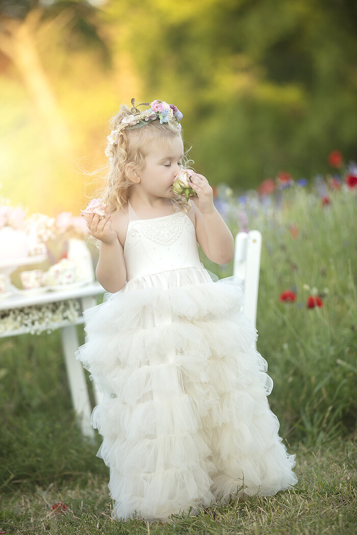 Little girl smelling wildflowers.