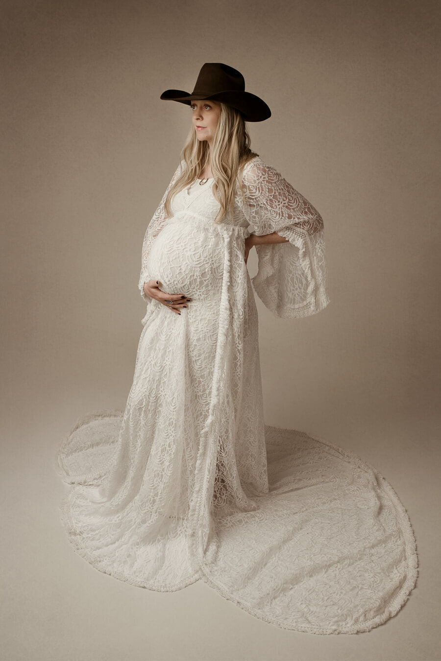 Boho maternity picture, woman in lace gown and cowboy hat
