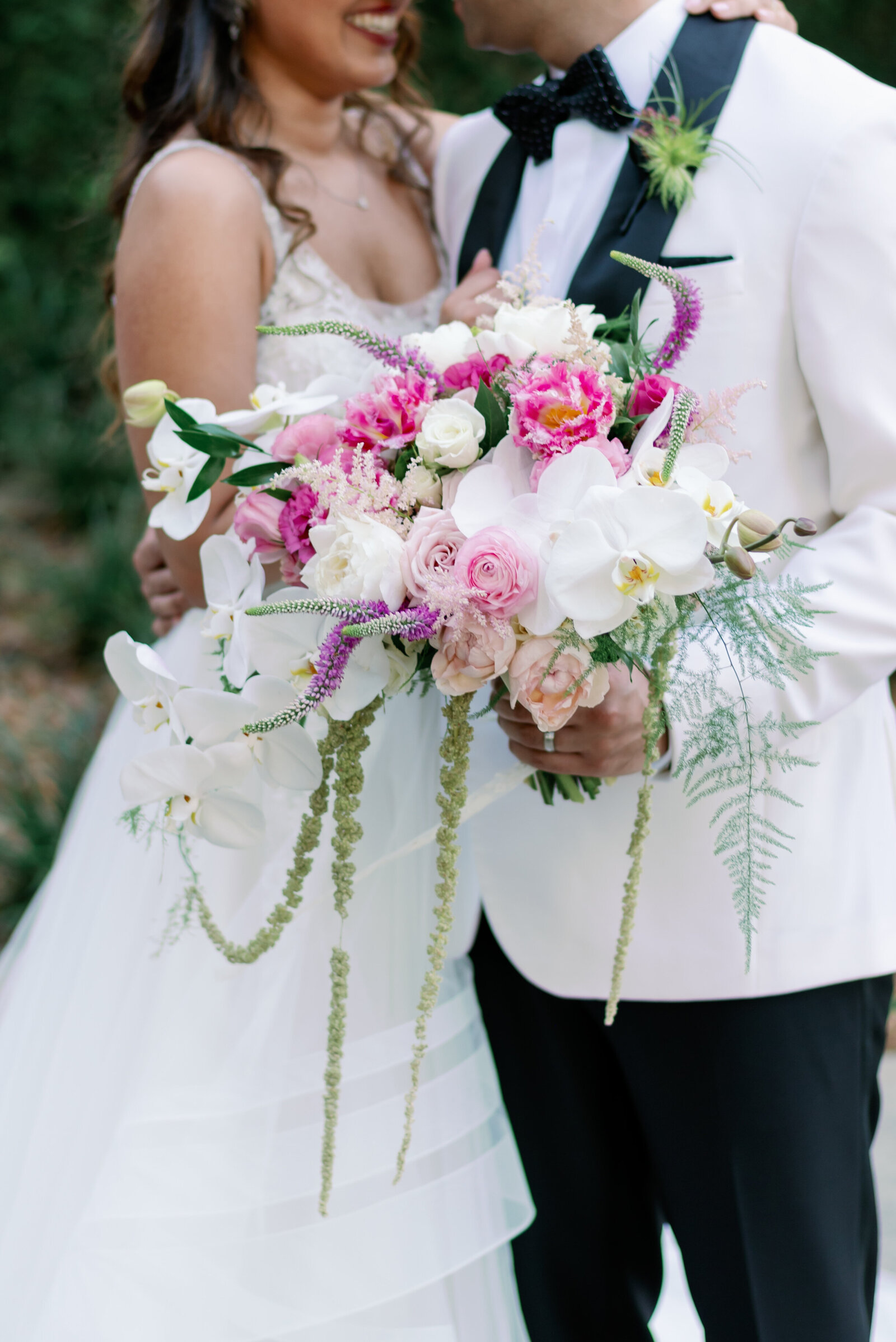 closeup of brides bouquet as they smile at each other