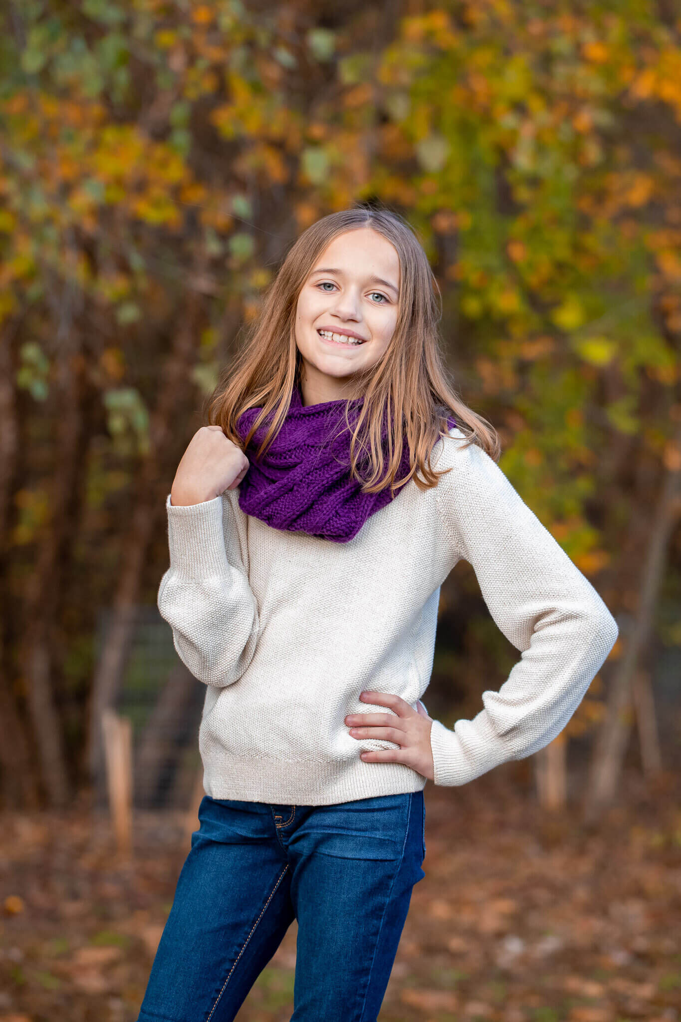 A young girl posing in jeans and a sweater in the fall in Northern Virginia.