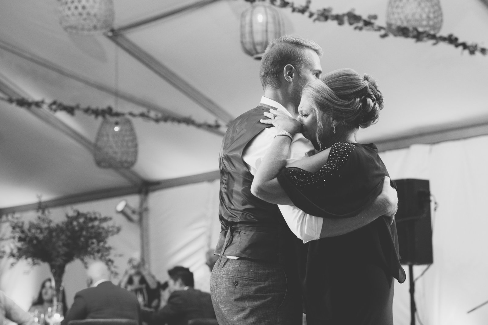 black and white photo of groom dancing with crying mom at Gurneys Montauk Resort wedding
