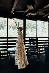 Newly married couple standing outside Airbnb cabin in North Georgia mountains for cinematic photos. Photos by Crimson Conure Photography based in Kennesaw, Georgia and Denver, Colorado