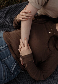 A close-up detail from a couple’s photoshoot in Maine, highlighting their hands and subtle connection. Fine art lifestyle photography by Damini Photography capturing intimate, romantic, and heartfelt moments.