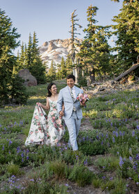 Couple walking through the wildflowers up at Timberline on Mount Hood during their elopement