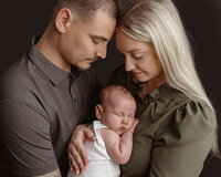 New parents holding their newborn baby during a family newborn photography session near Baton Rouge Louisiana